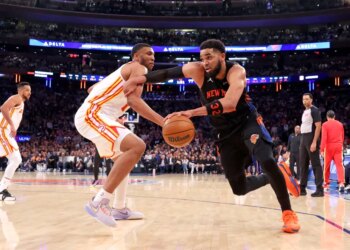New York Knicks center Karl-Anthony Towns (32) drives to the basket against an Atlanta Hawks player.