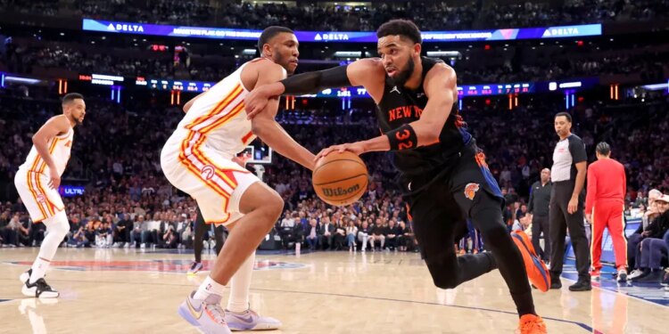 New York Knicks center Karl-Anthony Towns (32) drives to the basket against an Atlanta Hawks player.