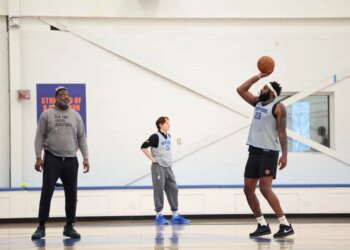 Mitchell Robinson #23 of the New York Knicks practices free throws, wearing a gray jersey and black shorts.