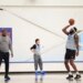 Mitchell Robinson #23 of the New York Knicks practices free throws, wearing a gray jersey and black shorts.