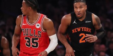 Miles McBride of the New York Knicks (right) and a Chicago Bulls player (left) on the court during an NBA game.