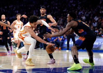 Atlanta Hawks forward Jalen Johnson and New York Knicks forward OG Anunoby reach for the ball