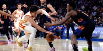 Atlanta Hawks forward Jalen Johnson and New York Knicks forward OG Anunoby reach for the ball
