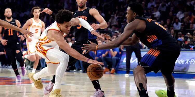 Atlanta Hawks forward Jalen Johnson and New York Knicks forward OG Anunoby reach for the ball