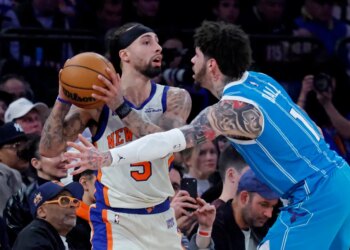 New York Knicks guard Jose Alvarado defends against Charlotte Hornets guard LaMelo Ball during a game.