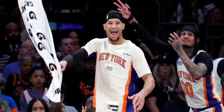 Basketball players Josh Hart and Jordan Clarkson of the New York Knicks react after scoring a three-point shot.