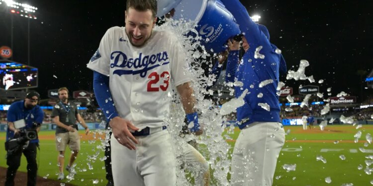 Los Angeles Dodgers right fielder Kyle Tucker (23) is doused with ice water from a cooler by right fielder Alex Call (12) after Tucker's walk-off single.