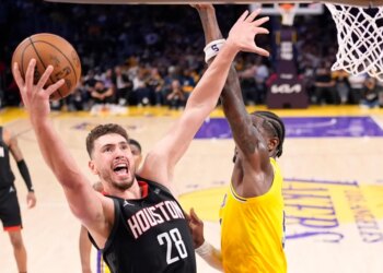 Alperen Sengun of the Houston Rockets preparing to score as Deandre Ayton defends.