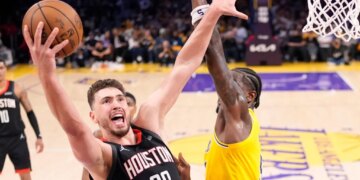 Alperen Sengun of the Houston Rockets preparing to score as Deandre Ayton defends.