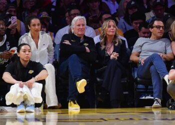 Los Angeles Lakers majority owner Mark Walter and team executive Jeannie Buss sit courtside at an NBA game.