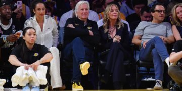 Los Angeles Lakers majority owner Mark Walter and team executive Jeannie Buss sit courtside at an NBA game.