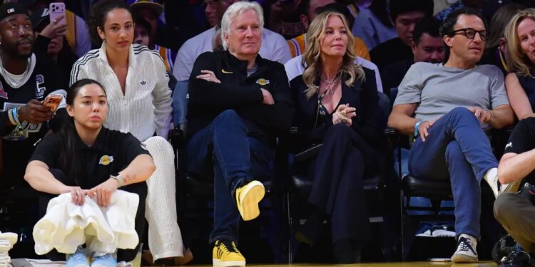 Los Angeles Lakers majority owner Mark Walter and team executive Jeannie Buss sit courtside at an NBA game.