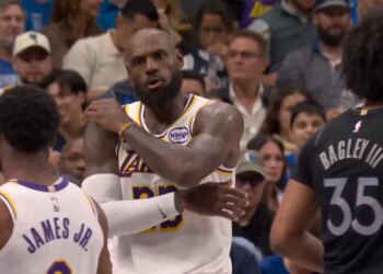 LeBron James, in a Lakers jersey, gestures with his arms crossed while talking to his son, Bronny James Jr. in a Lakers jersey.
