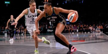 Betnijah Laney-Hamilton of the New York Liberty drives with the basketball, defended by Natisha Hiedeman of the Minnesota Lynx, during Game 5 of the 2024 WNBA Finals.