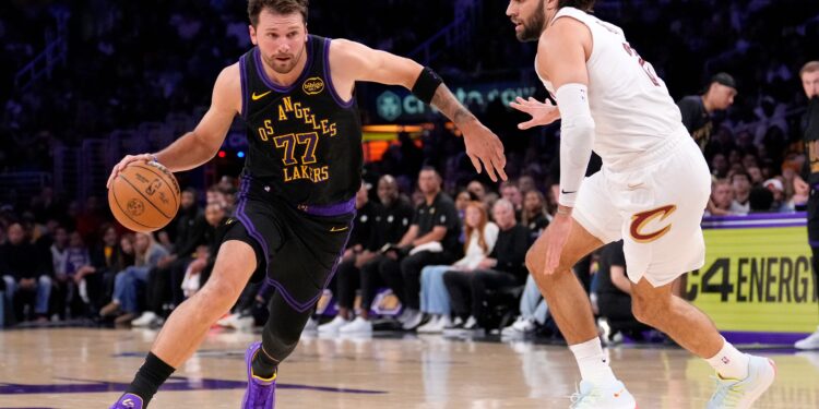 Luka Doncic drives past Max Strus during an NBA game.