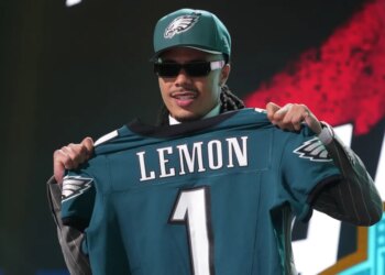 Makai Lemon posing with a Philadelphia Eagles jersey with his name and number 1 on the back.