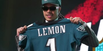 Makai Lemon posing with a Philadelphia Eagles jersey with his name and number 1 on the back.