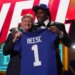 NFL Commissioner Roger Goodell and Arvell Reese holding up a New York Giants jersey with "Reese" and the number "1" on it.