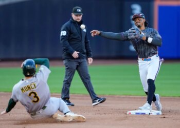 Mets shortstop Francisco Lindor, right, throws to first base after a force out against Athletics' Max Muncy (3) at second base during the fifth inning of a baseball game, Saturday, April 11, 2026.