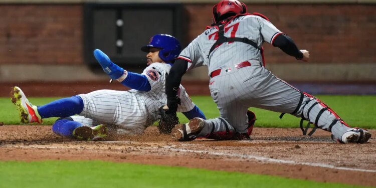 Francisco Lindor slides safely into home on Francisco Alvarez's double in the fourth inning on April 22, 2026 at Citi Field but had to later leave the game with left calf tightness.