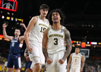Michigan's Elliot Cadeau (3) reacts while teammate Aday Mara (15) watches during the first half of an NCAA college basketball tournament game.