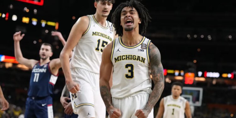 Michigan's Elliot Cadeau (3) reacts while teammate Aday Mara (15) watches during the first half of an NCAA college basketball tournament game.