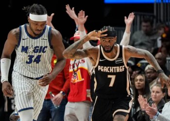 Atlanta Hawks guard Nickeil Alexander-Walker (7) celebrates a three-point shot as Orlando Magic player Wendell Carter Jr. (34) looks on.