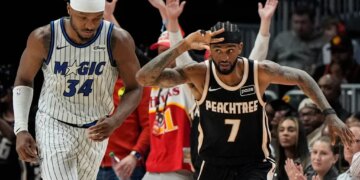 Atlanta Hawks guard Nickeil Alexander-Walker (7) celebrates a three-point shot as Orlando Magic player Wendell Carter Jr. (34) looks on.