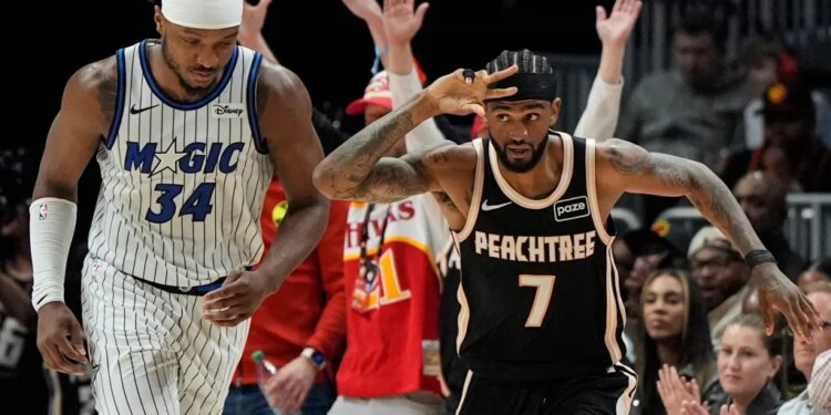 Atlanta Hawks guard Nickeil Alexander-Walker (7) celebrates a three-point shot as Orlando Magic player Wendell Carter Jr. (34) looks on.