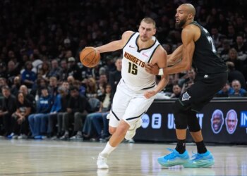 Nikola Jokic works toward the basket while Rudy Gobert defends him in an NBA playoff game.