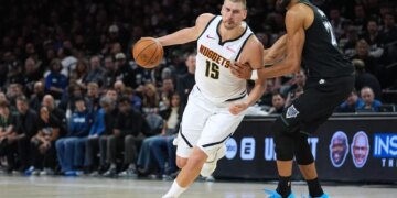 Nikola Jokic works toward the basket while Rudy Gobert defends him in an NBA playoff game.