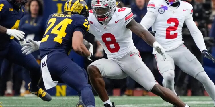 Ohio State Buckeyes linebacker Arvell Reese (8) tackling Michigan Wolverines running back Bryson Kuzdzal (24).