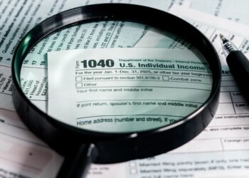 A magnifying glass and pen over a 2025 US Individual Income Tax Form 1040.
