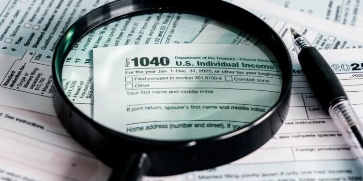 A magnifying glass and pen over a 2025 US Individual Income Tax Form 1040.