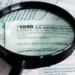 A magnifying glass and pen over a 2025 US Individual Income Tax Form 1040.