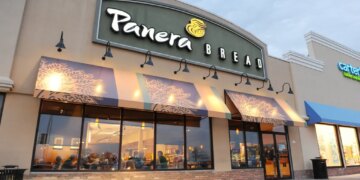 Exterior of a Panera Bread restaurant with its sign and awnings, next to a Carter's store.