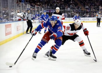 Dawson Mercer #91 of the New Jersey Devils checks left wing Adam Sykora #38 of the New York Rangers during the first period at Madison Square Garden, Tuesday, March 31, 2026, in New York, NY.