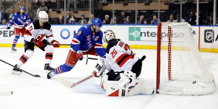 New York Rangers player J.T. Miller #8 scores a goal past New Jersey Devils goaltender Jacob Markstrom #25.