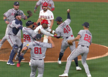 Baseball players from two teams engaging in a brawl on the pitcher's mound.