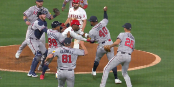 Baseball players from two teams engaging in a brawl on the pitcher's mound.