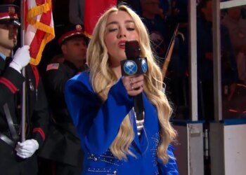 Sabres anthem singer Cami Clune looks at the microphone as it cuts out during "O Canada" on April 28, 2026.