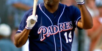 Tony Gwynn acknowledging the crowd, holding his helmet in one hand and a bat in the other.
