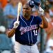Tony Gwynn acknowledging the crowd, holding his helmet in one hand and a bat in the other.