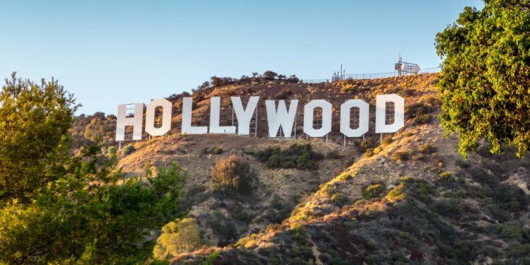 The Hollywood sign on a hill under a clear sky.