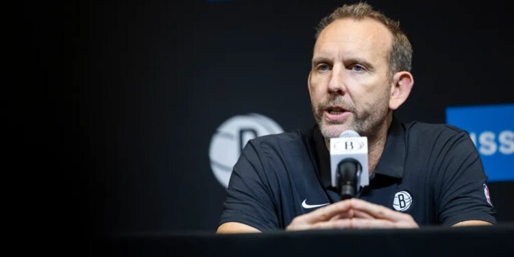 Brooklyn Nets GM Sean Marks speaks into a microphone.