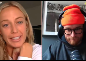 Two people, a blonde woman and a bearded man in a beanie and headphones, in a video call.