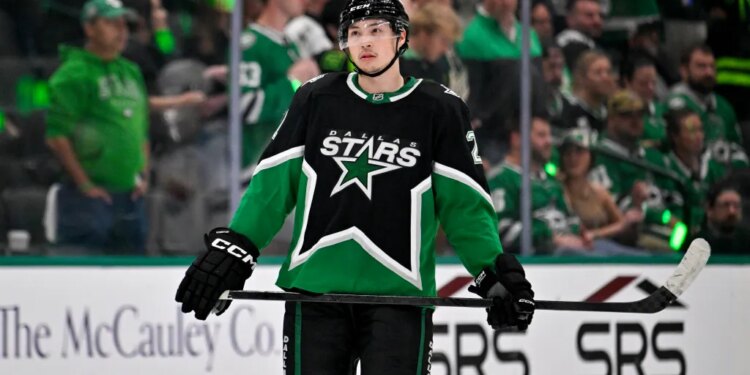 Dallas Stars left wing Jason Robertson in black and green uniform with his hockey stick.