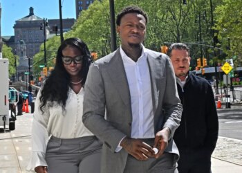 Former NBA player Terry Rozier, in a grey suit, arrives at federal court for oral argument in his case.