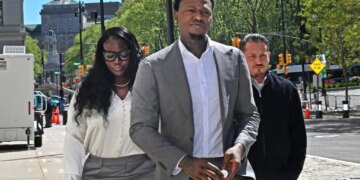 Former NBA player Terry Rozier, in a grey suit, arrives at federal court for oral argument in his case.