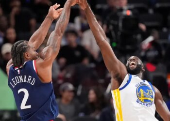 Kawhi Leonard shooting over Draymond Green during a basketball game.